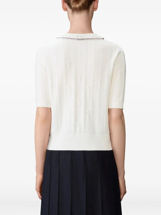 White knitwear worn by a person, showing the knitwear's fit