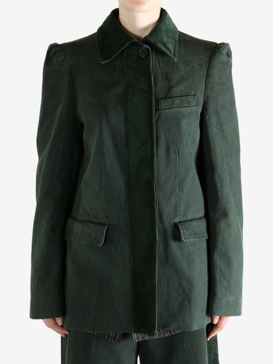 Green jacket worn by a person, showing the jacket's fit