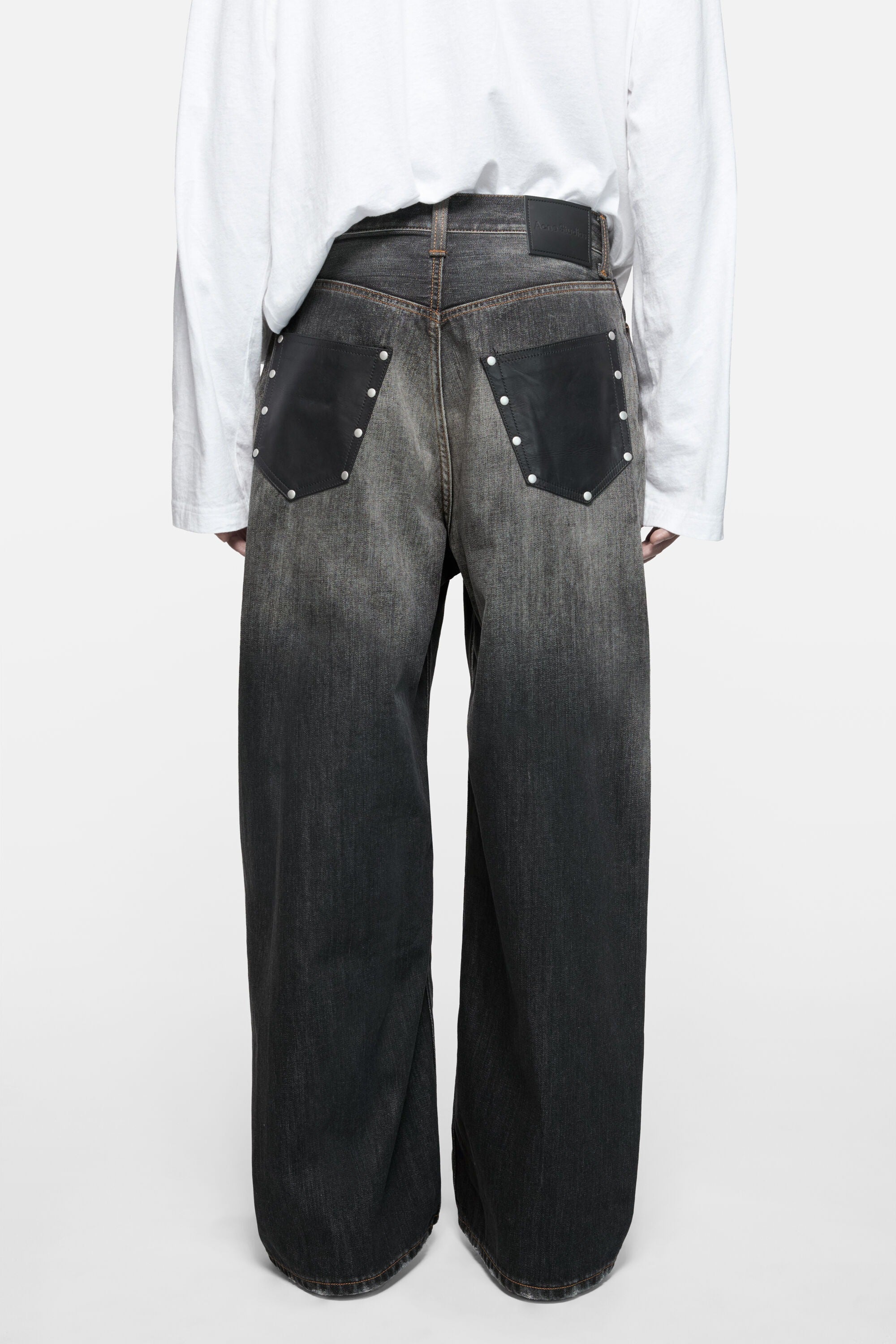 Black jeans worn by a person, showing the jeans fit