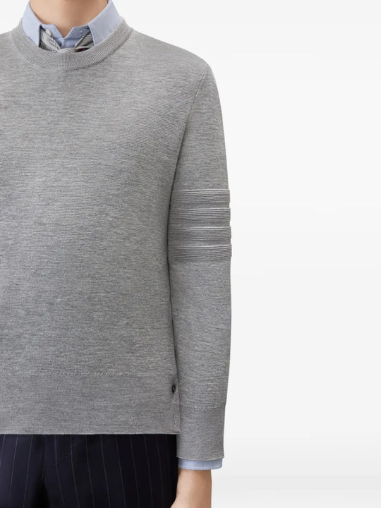 Grey knitwear worn by a person, showing the knitwear fit