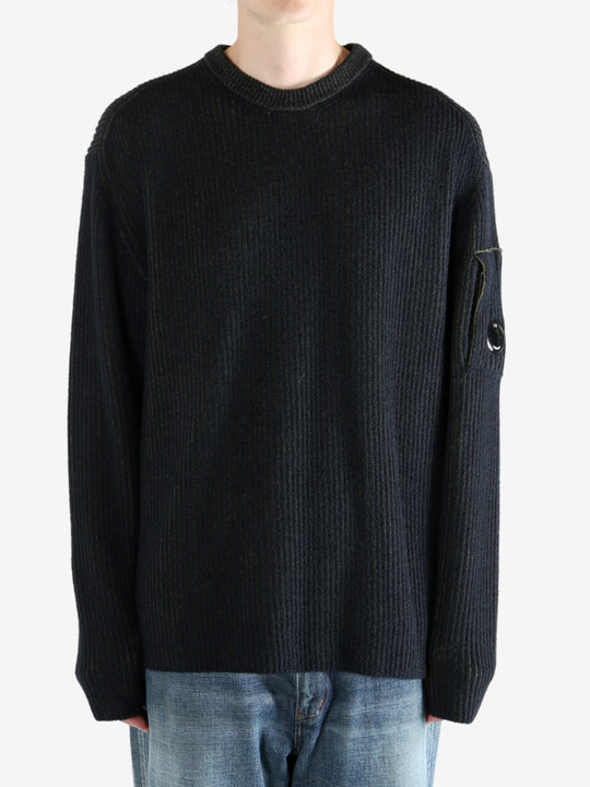 Black sweater worn by a person, showing the sweater fit