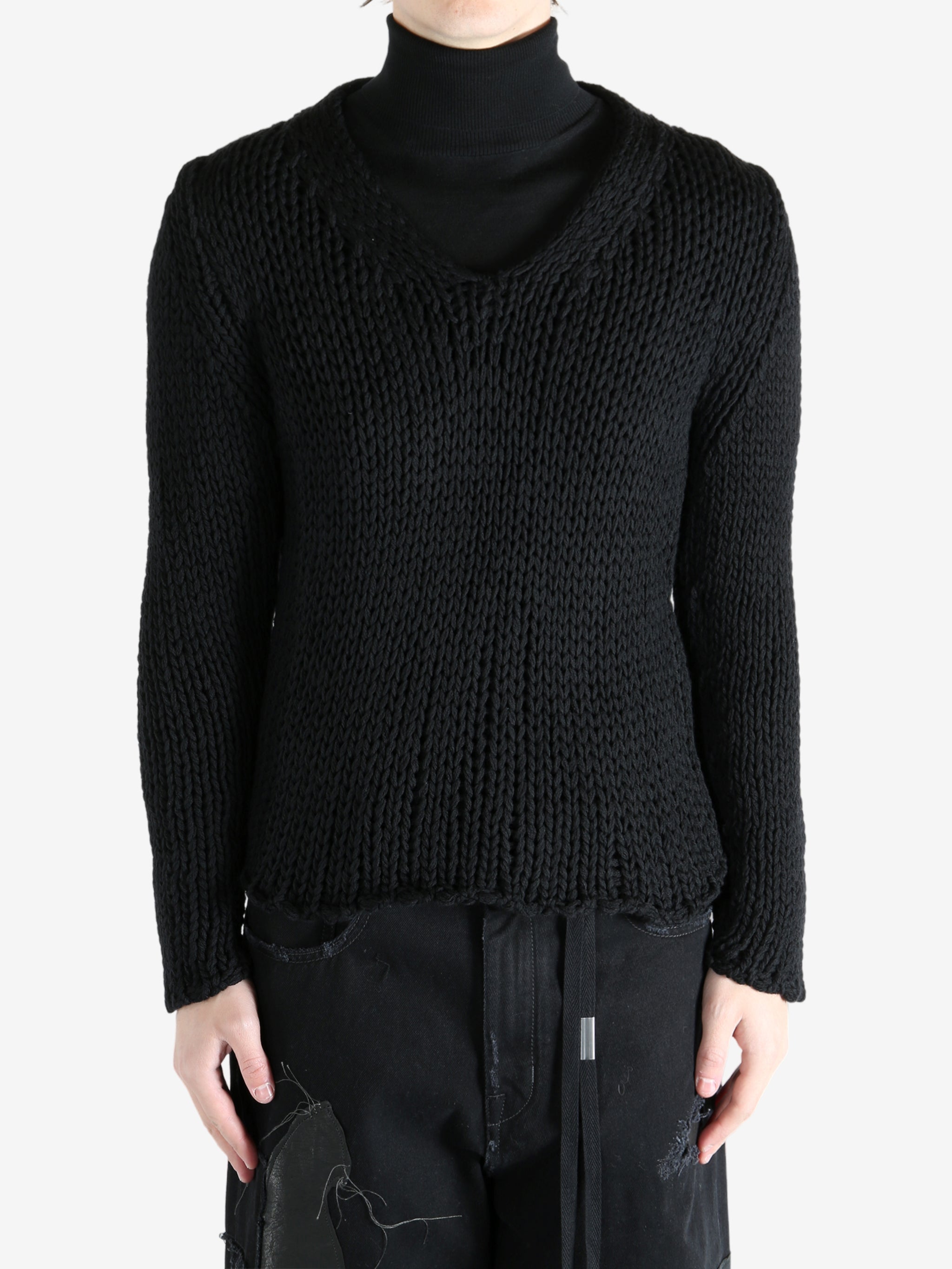 Black sweater worn by a person, showing the sweater's fit