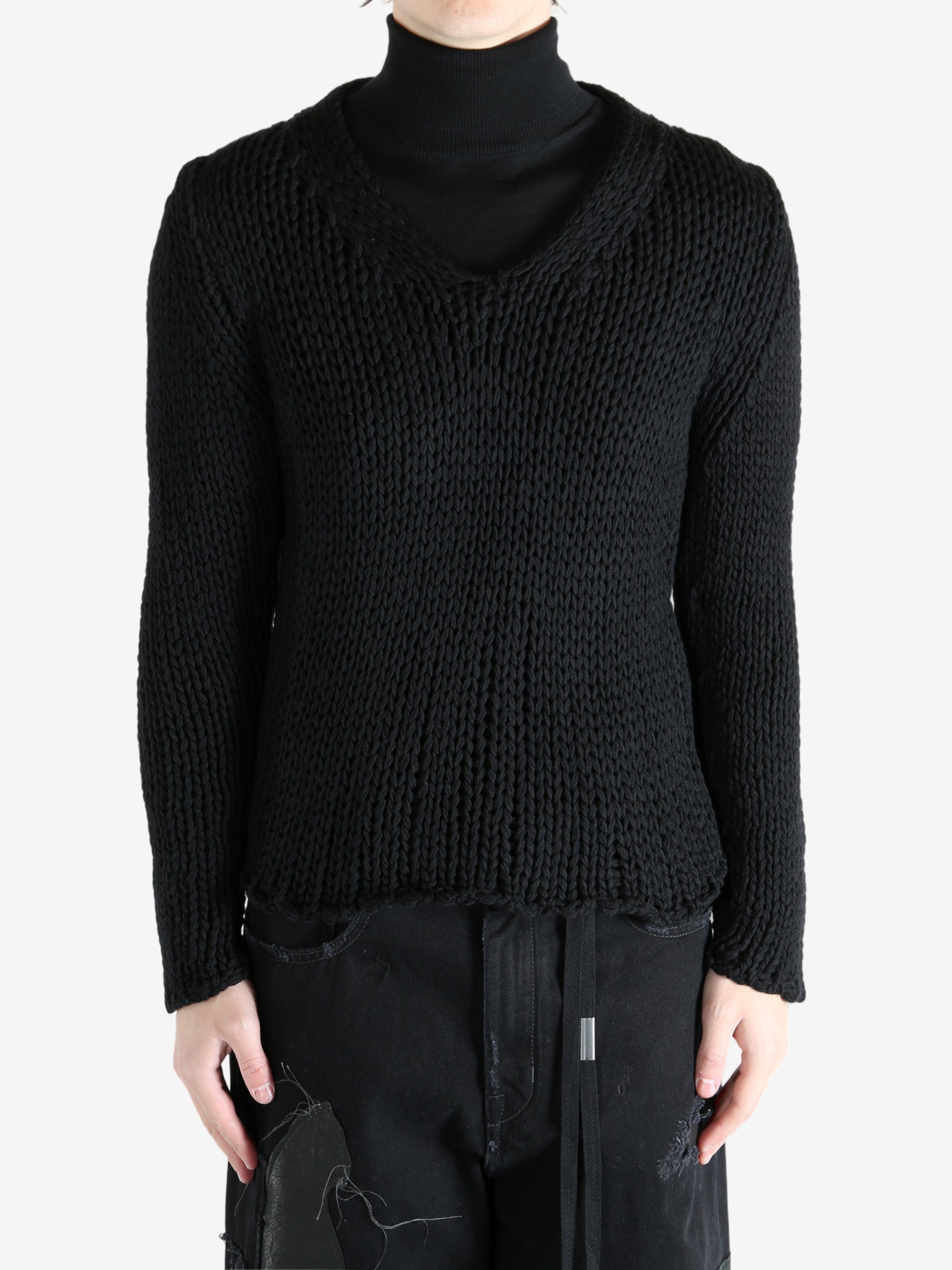Black sweater worn by a person, showing the sweater's fit