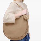 Tan bag worn by a person, showing the bag's fit