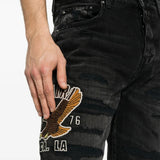 Black jeans worn by a person, showing the jeans fit