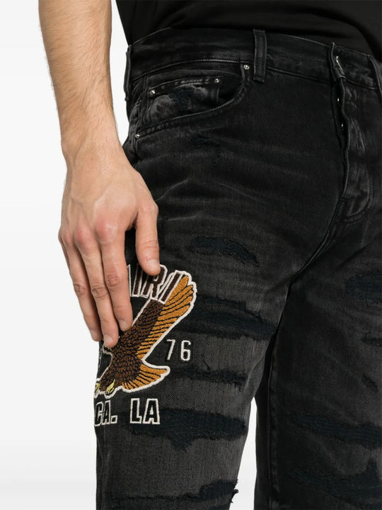 Black jeans worn by a person, showing the jeans fit