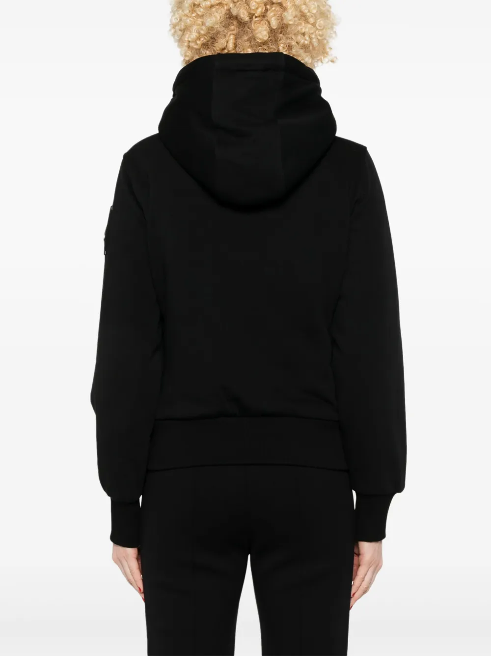 Black coat worn by a person, showing the coat fit