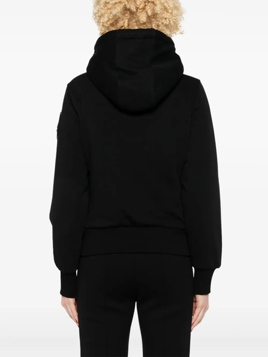 Black coat worn by a person, showing the coat fit