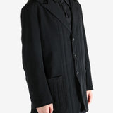 Black coat worn by a person, showing the coat fit