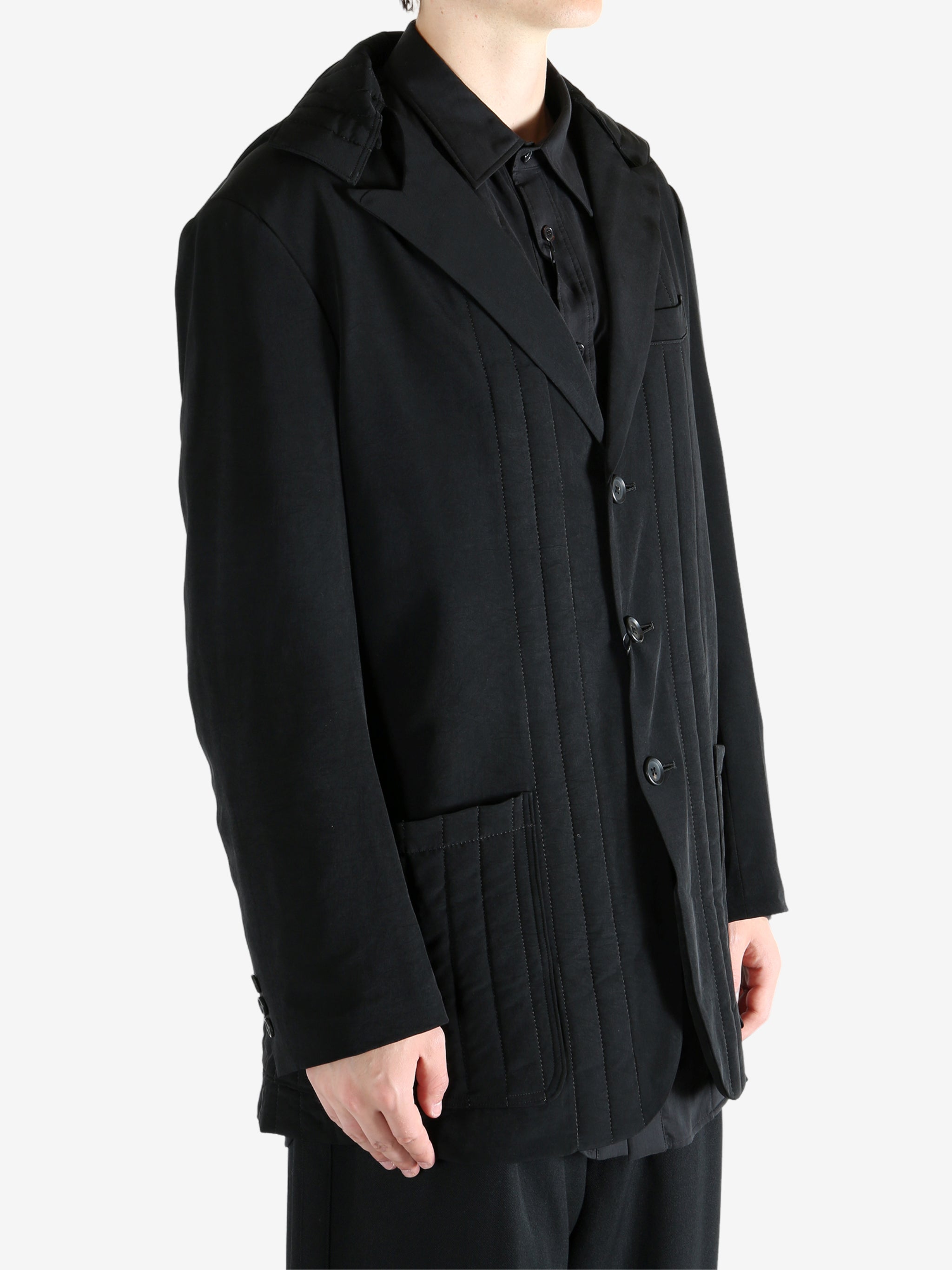Black coat worn by a person, showing the coat fit