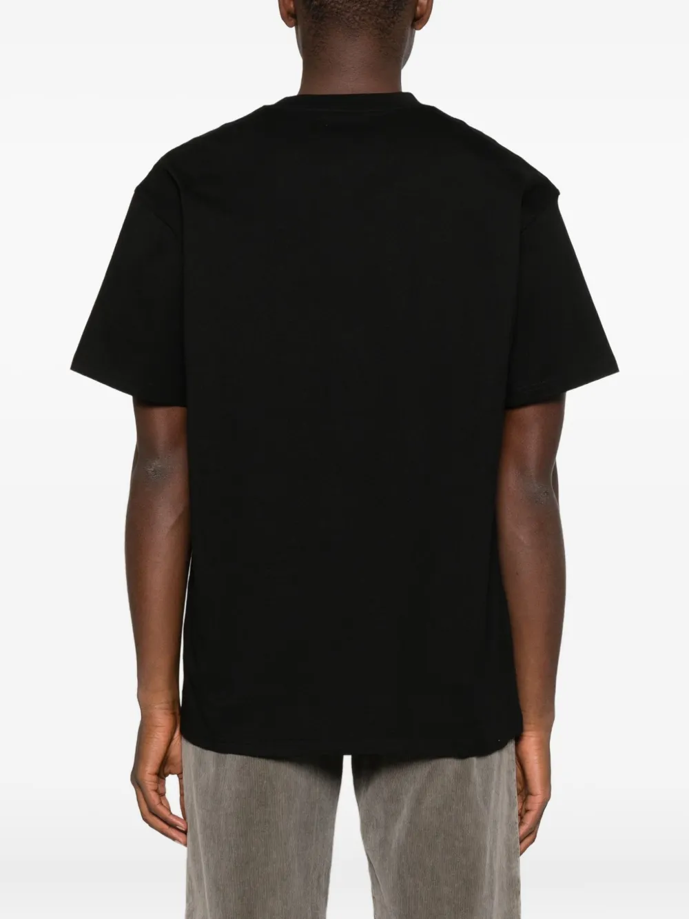 Black t-shirts worn by a person, showing the t-shirts fit