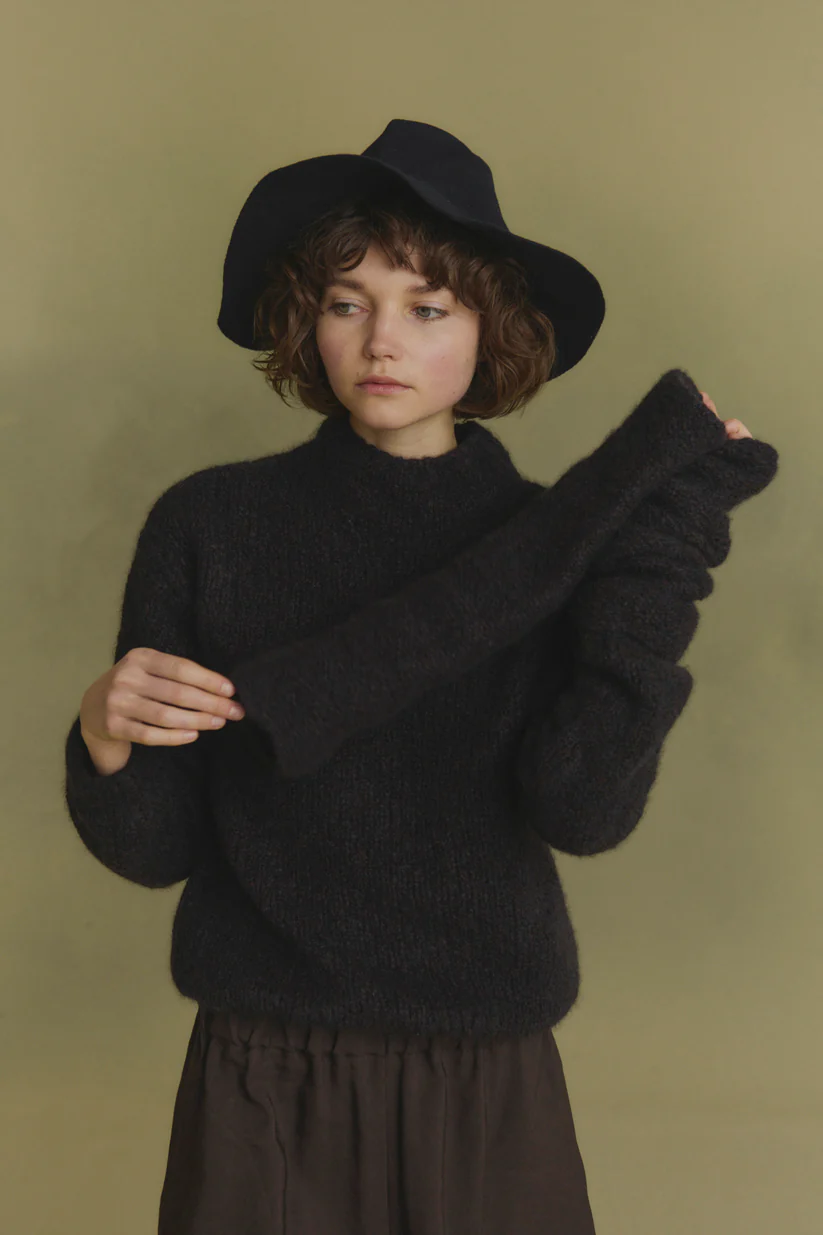 Navy knitwear worn by a person, showing the knitwear's fit
