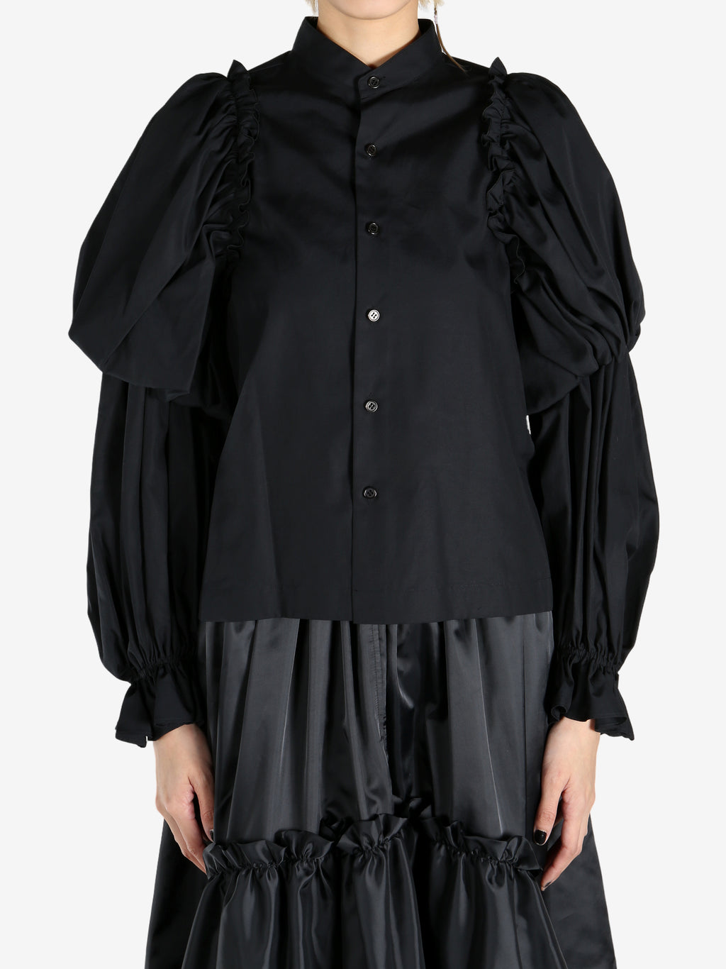 Black tops worn by a person, showing the tops fit