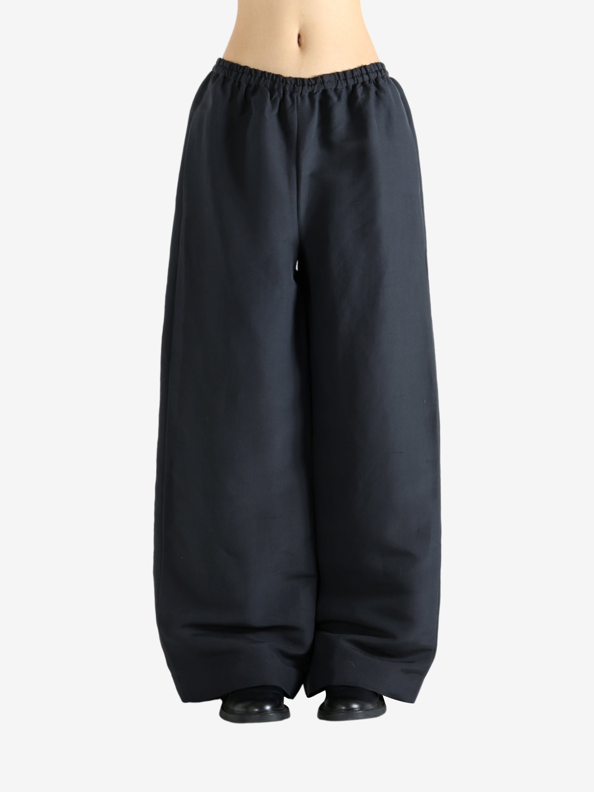 Black pants worn by a person, showing the pants' fit