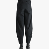 Black pants worn by a person, showing the pants's fit