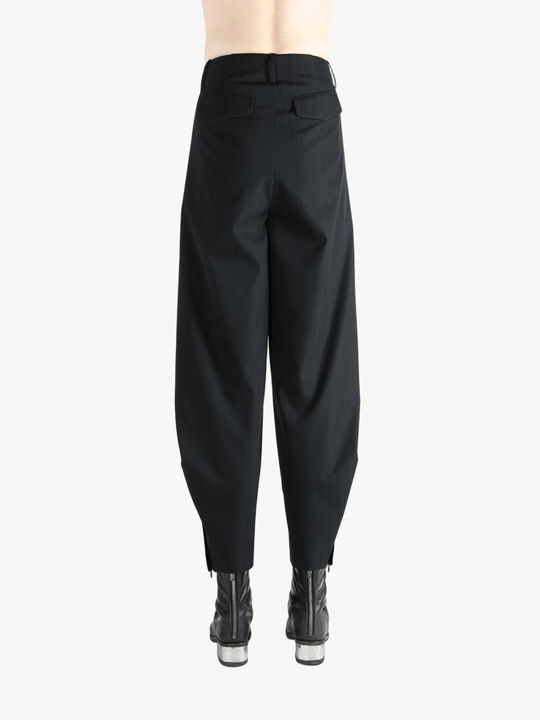 Black pants worn by a person, showing the pants's fit