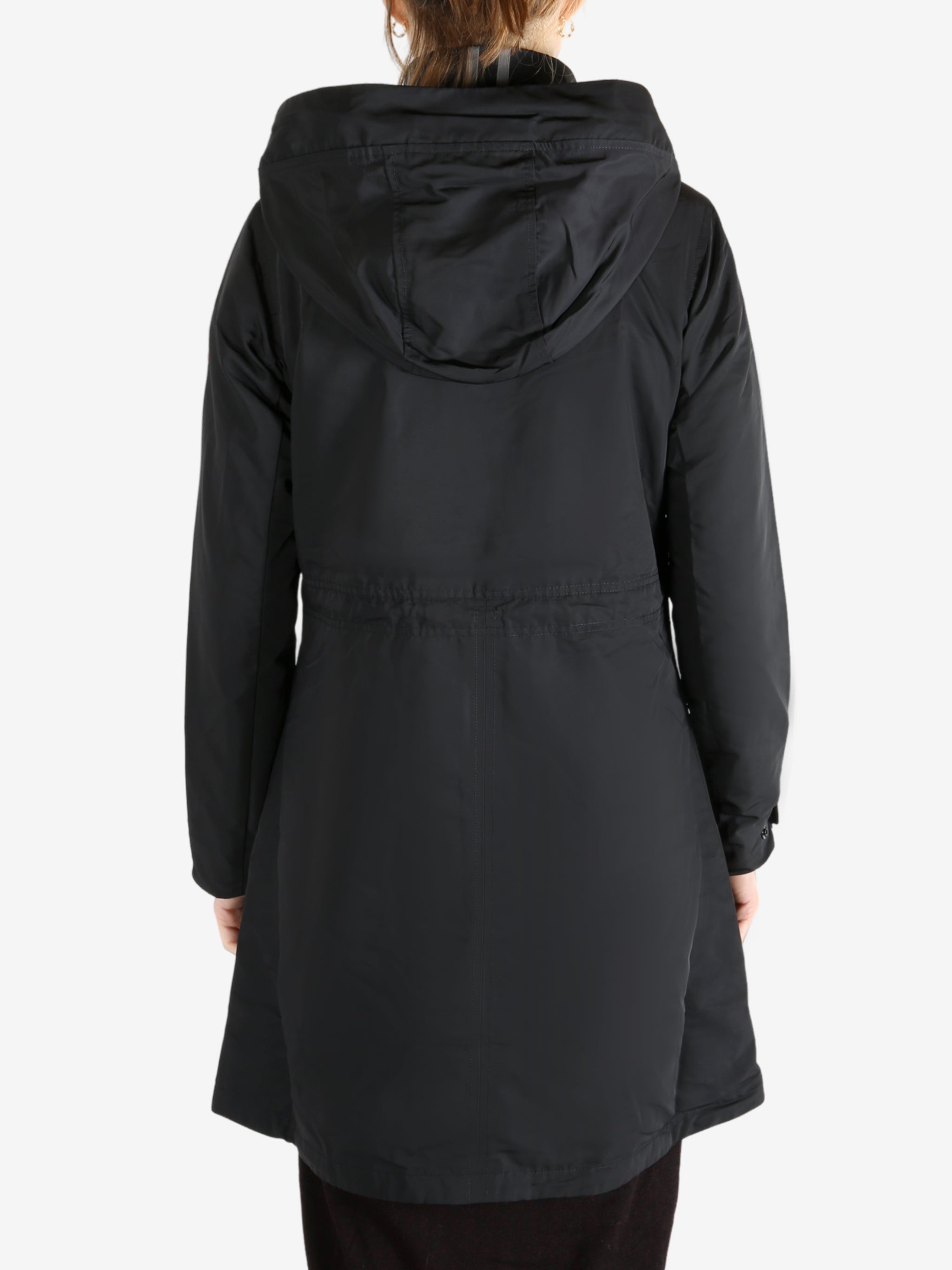 Black coat worn by a person, showing the coat fit