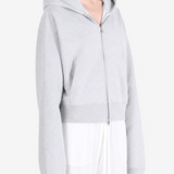 Grey hoodie worn by a person, showing the hoodie fit
