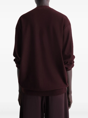 Burgundy knitwear worn by a person, showing the knitwear’s fit