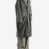 Grey coat worn by a person, showing the coat's fit