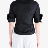 Black shirt worn by a person, showing the shirt fit