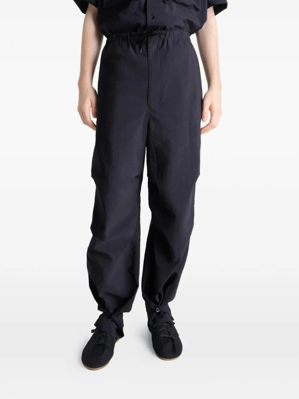 Black pants worn by a person, showing the pants' fit