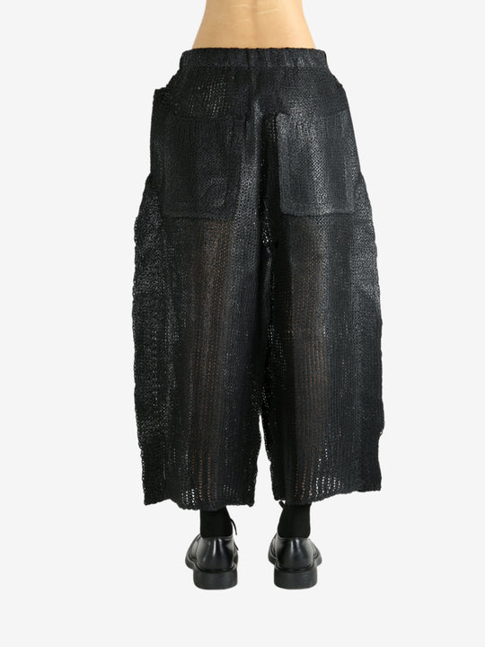 Black pants worn by a person, showing the pants' fit