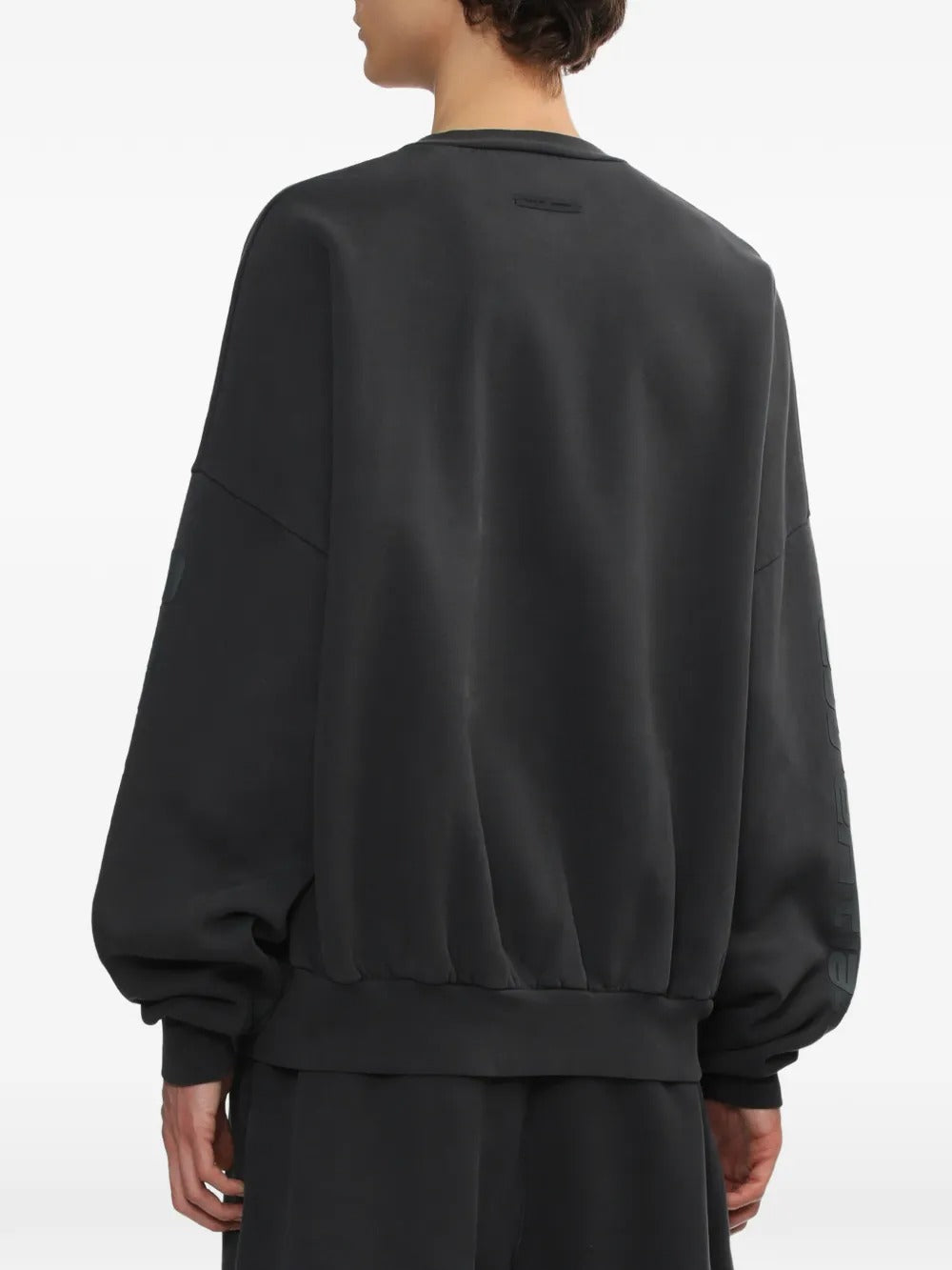 Black sweatshirt worn by a person, showing the sweatshirt's fit