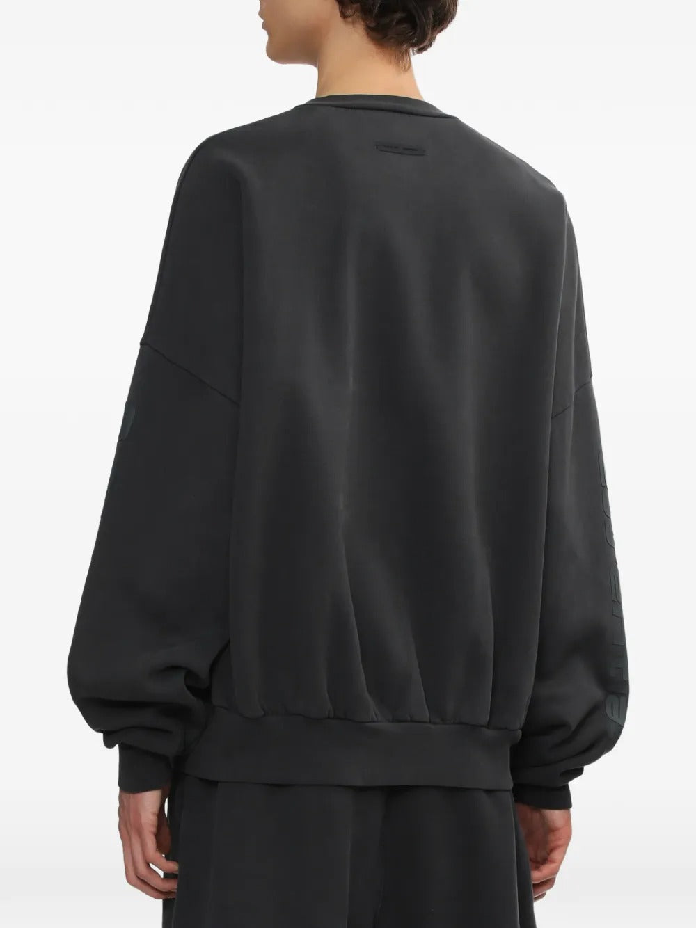 Black sweatshirt worn by a person, showing the sweatshirt's fit