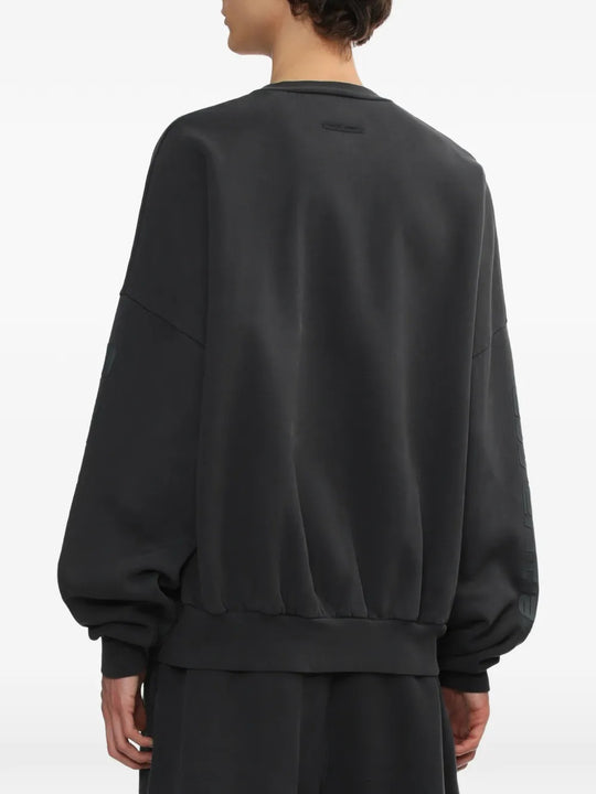 Black sweatshirt worn by a person, showing the sweatshirt's fit
