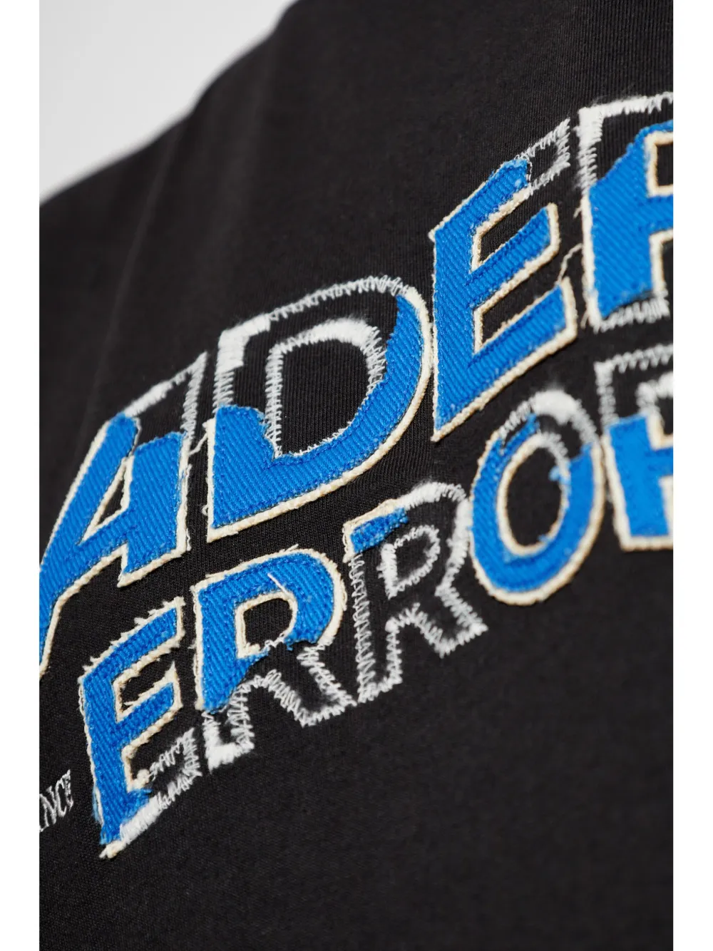 Close up of black tee, showing the detial of logo