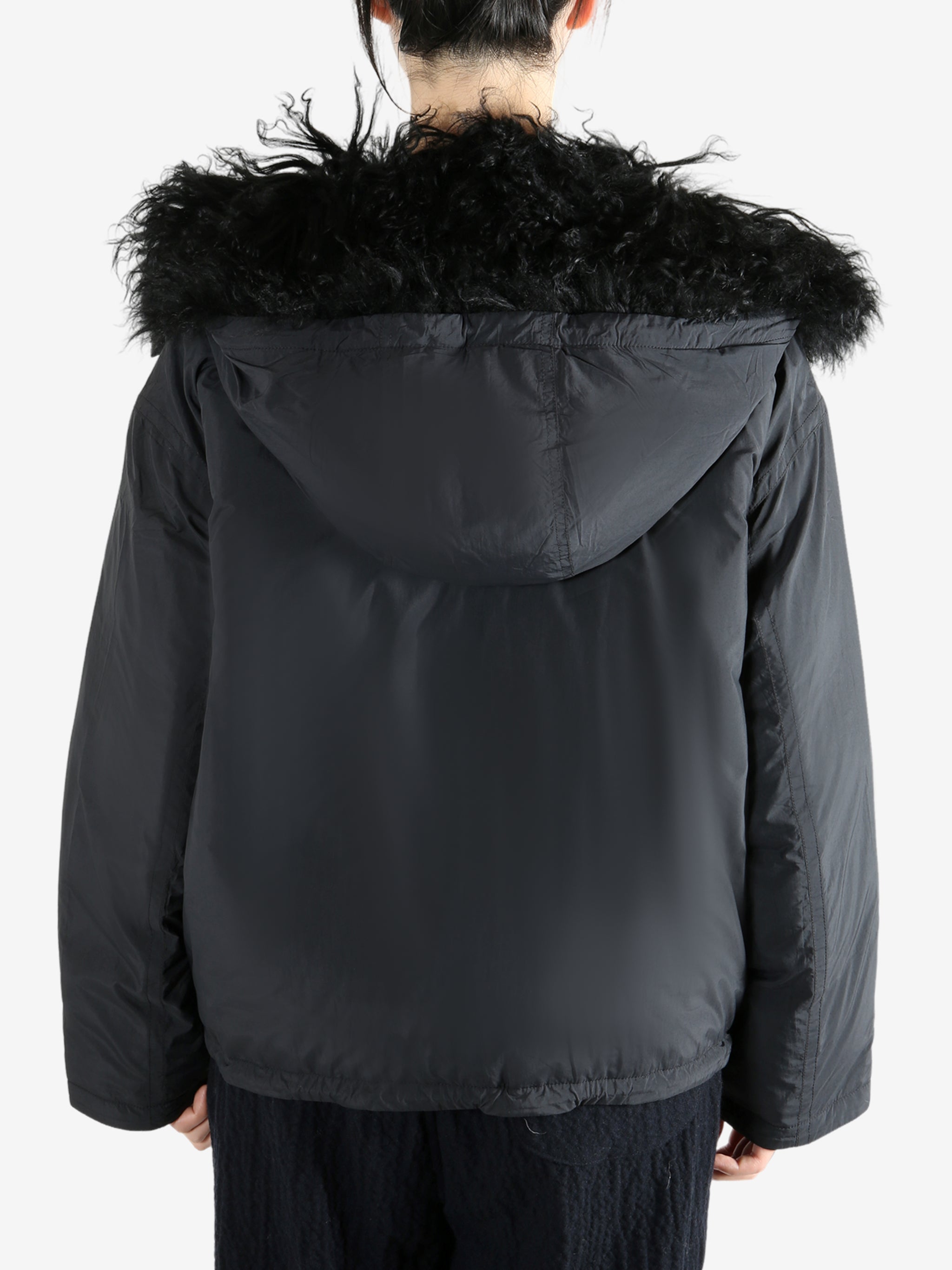 Black coat worn by a person, showing the coat's fit