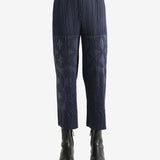 Navy pleated pants  worn by a person, showing the pants fit