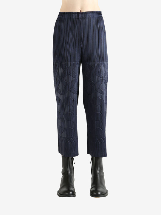 Navy pleated pants  worn by a person, showing the pants fit