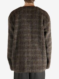 Brown knitwear worn by a person, showing the knitwear's fit