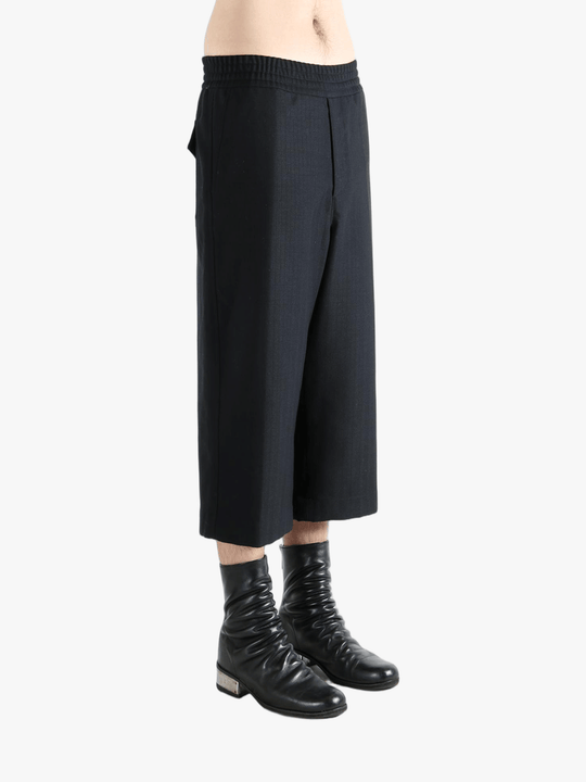 Black pants worn by a person, showing the pants's fit