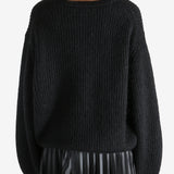 Black knitwear worn by a person, showing the knitwear fit