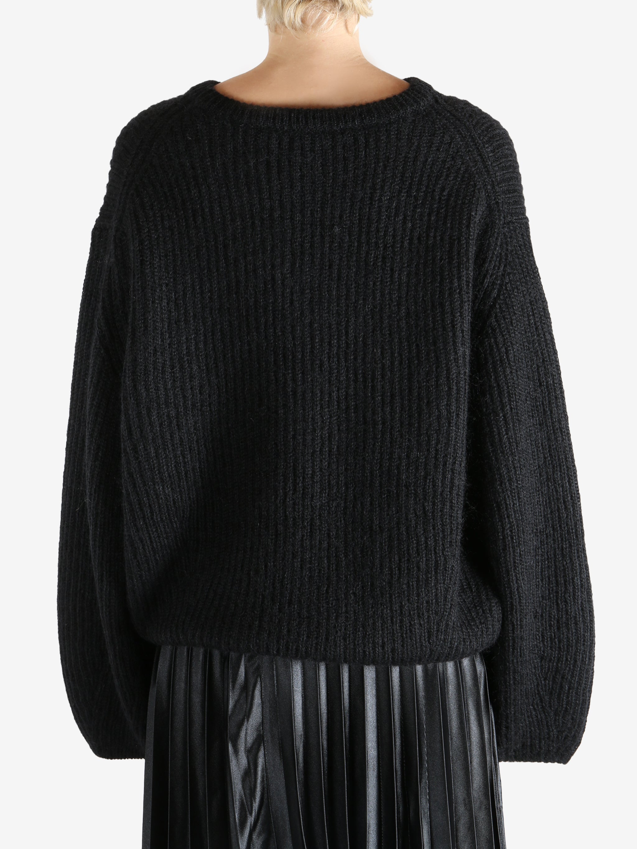 Black knitwear worn by a person, showing the knitwear fit