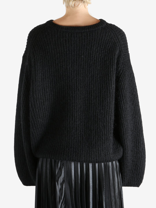 Black knitwear worn by a person, showing the knitwear fit