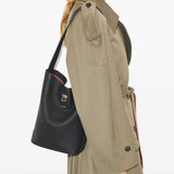 Black bucket bag by a person, showing the bucket bag fit