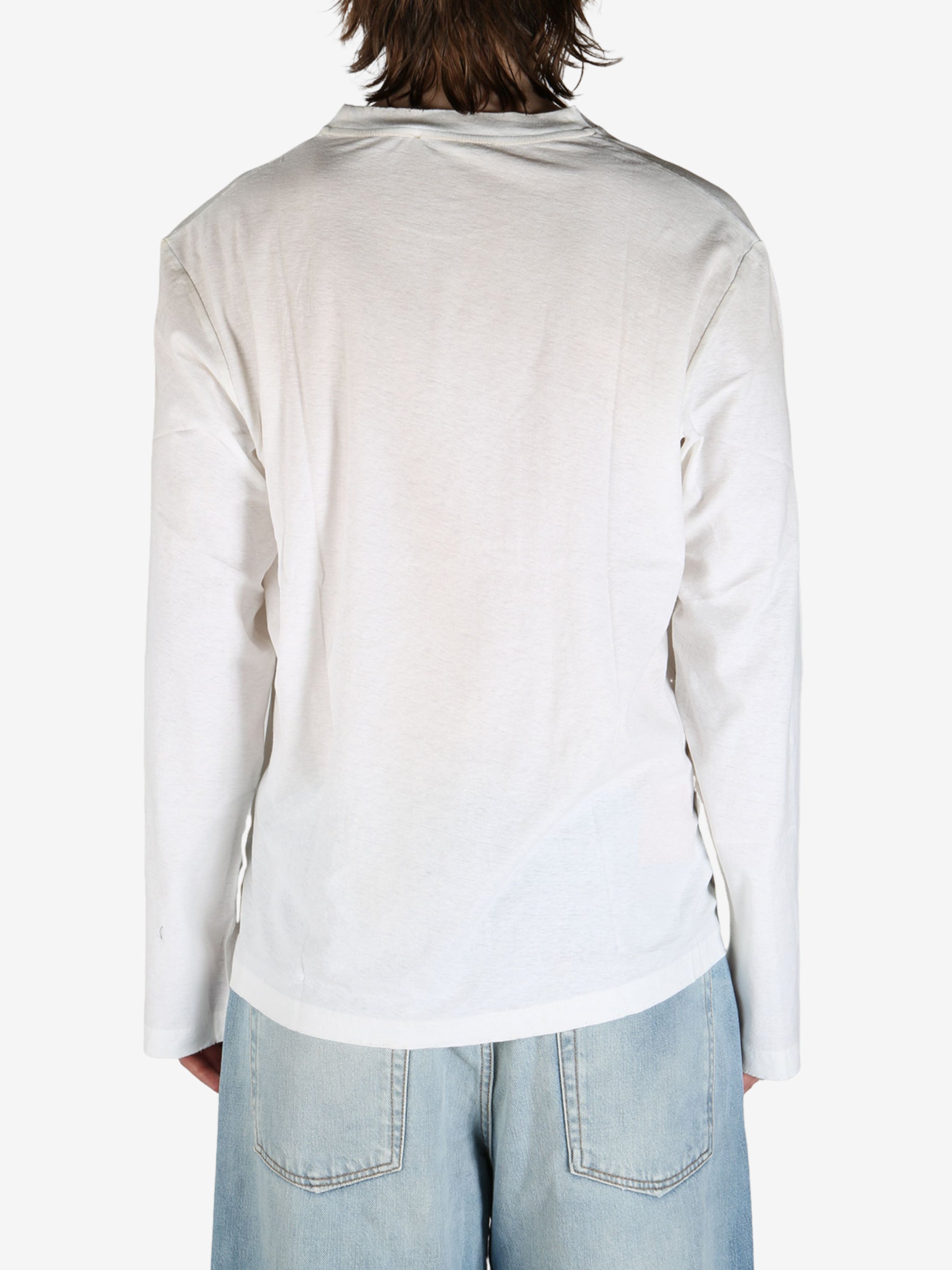 White tee worn by aperson, showing the tee's fit