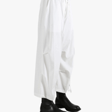 White pants worn by a person, showing the pants' fit