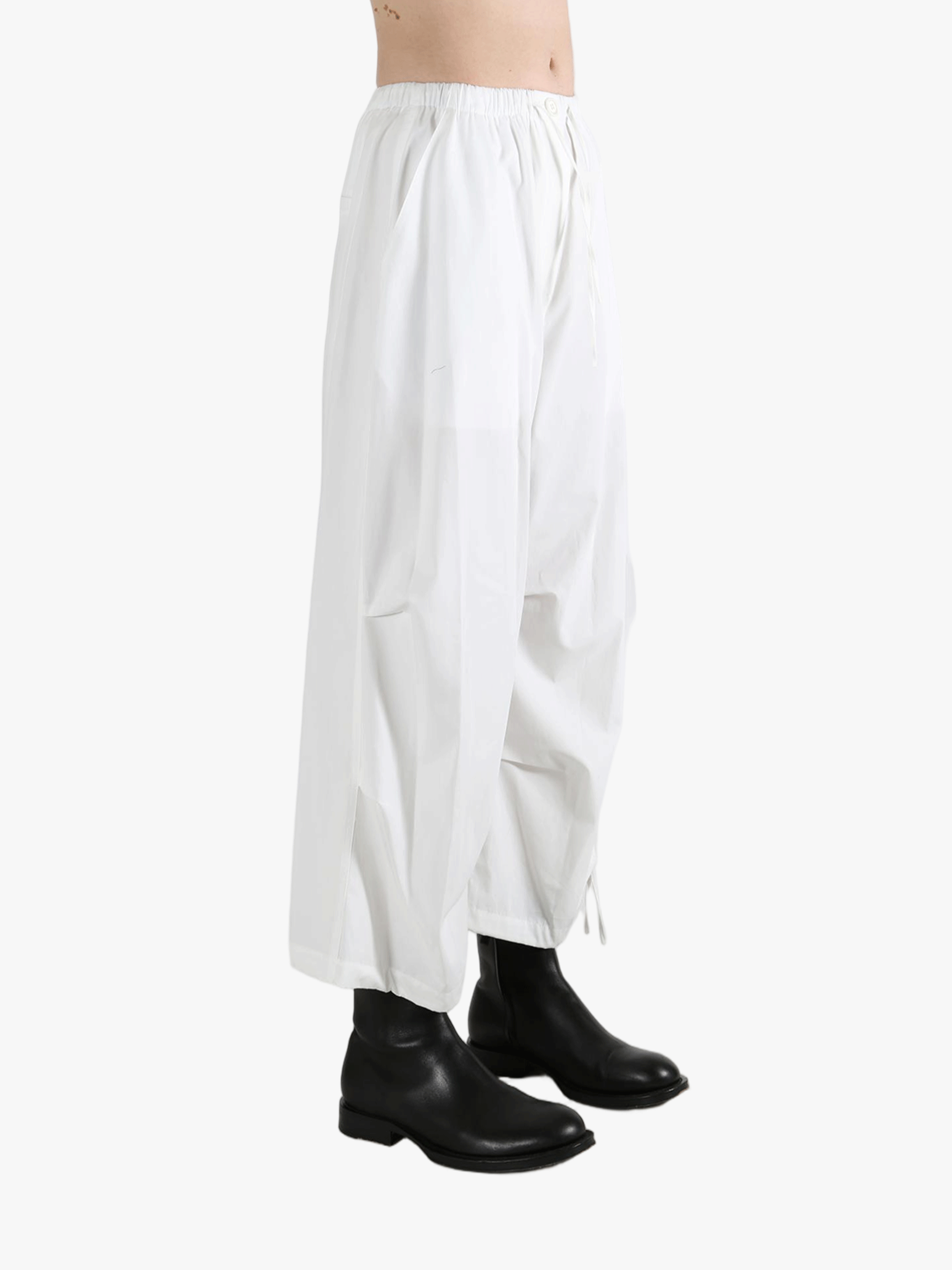 White pants worn by a person, showing the pants' fit