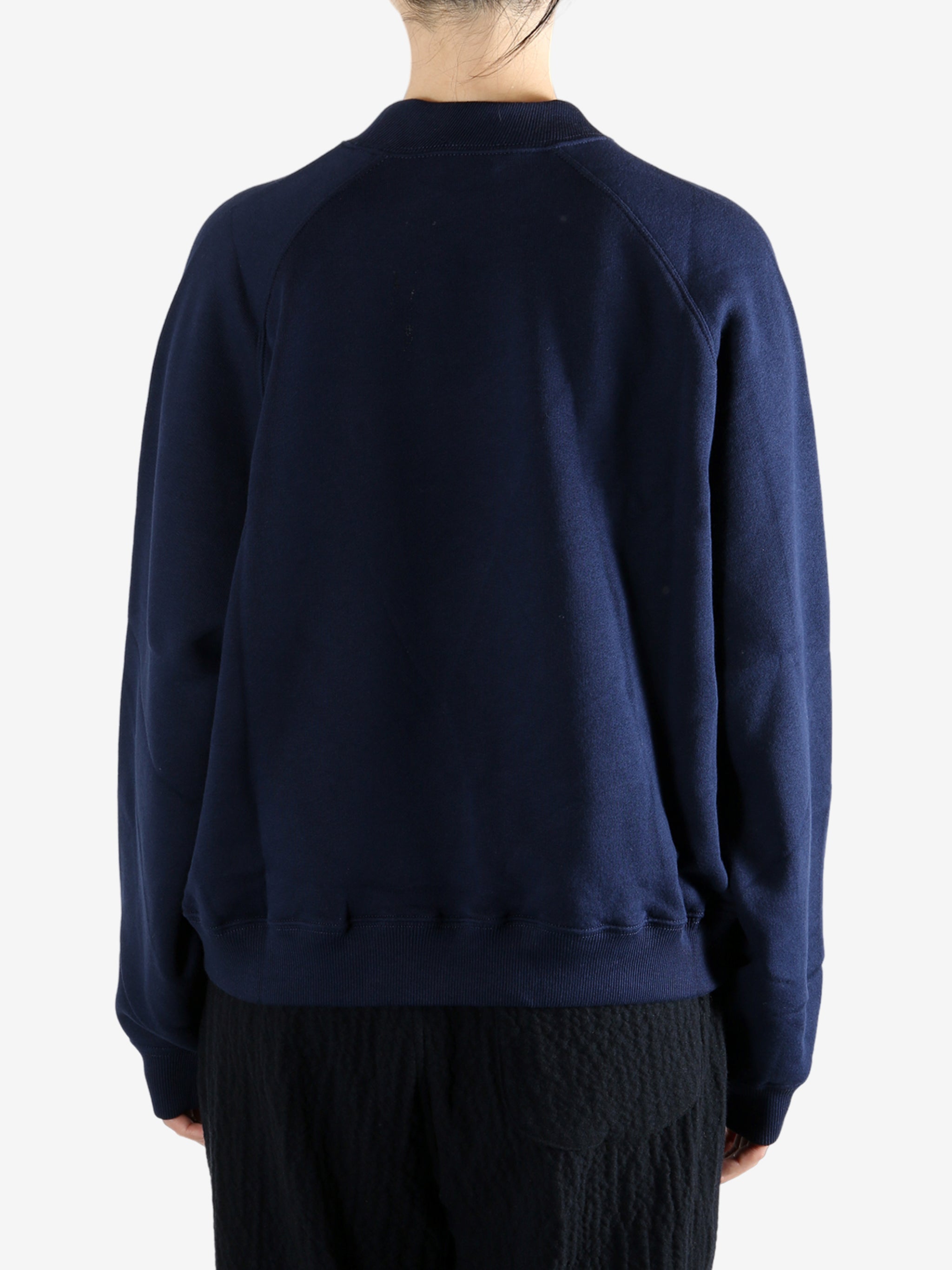 Navy knitwear worn by a person, showing the knitwear fit