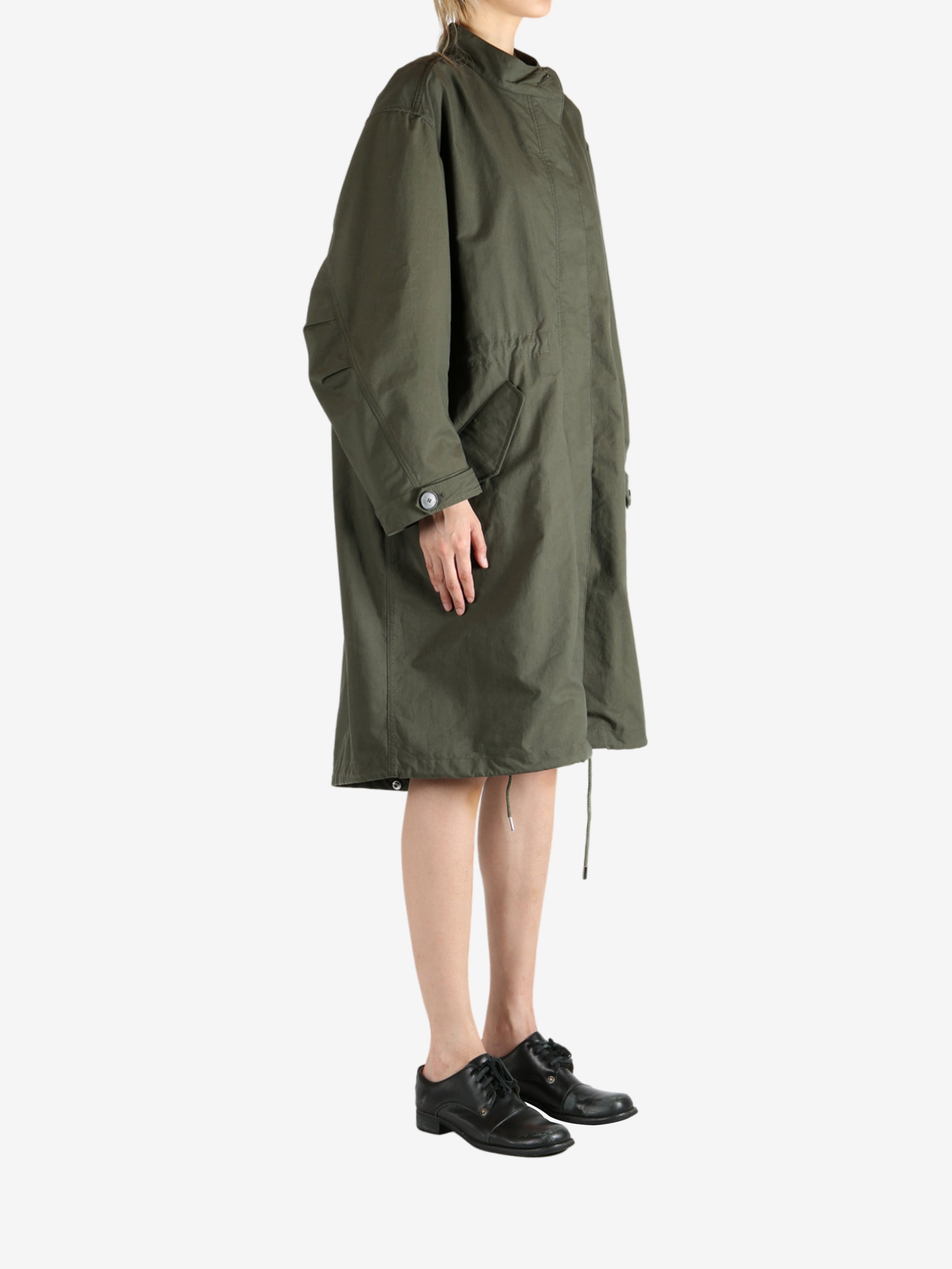 Green coat worn by a person, showing the coat fit