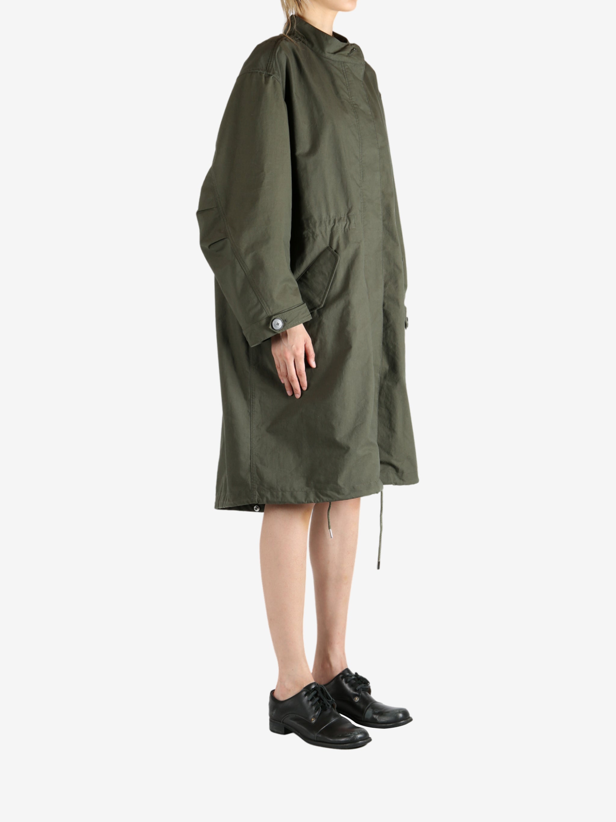 Green coat worn by a person, showing the coat fit