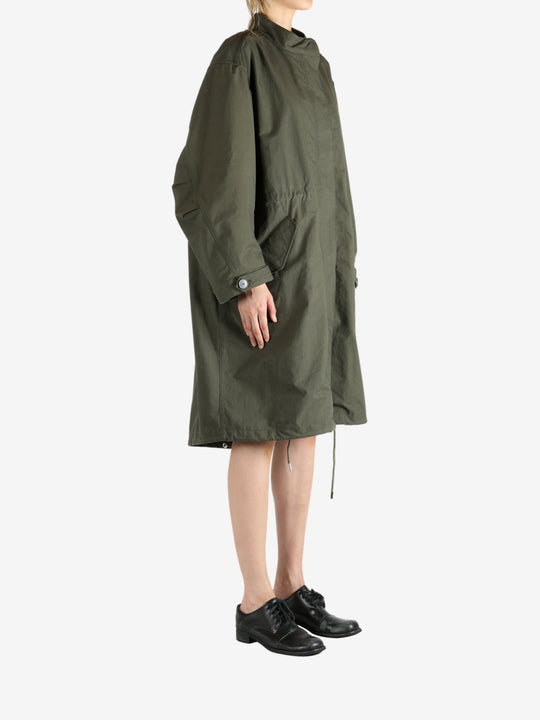 Green coat worn by a person, showing the coat fit