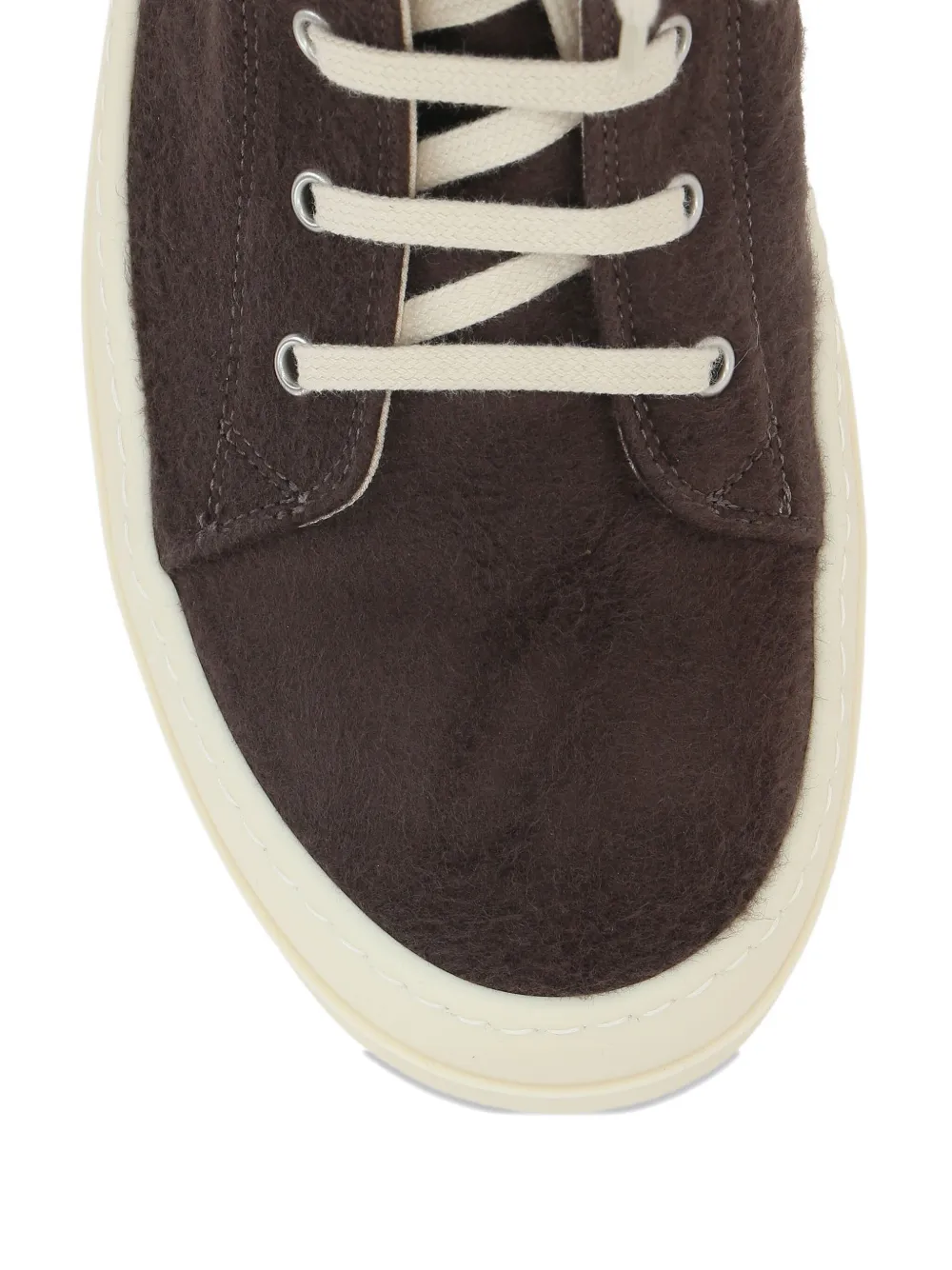 Close up of the brown sneakers, showing texture of the cotton fabric