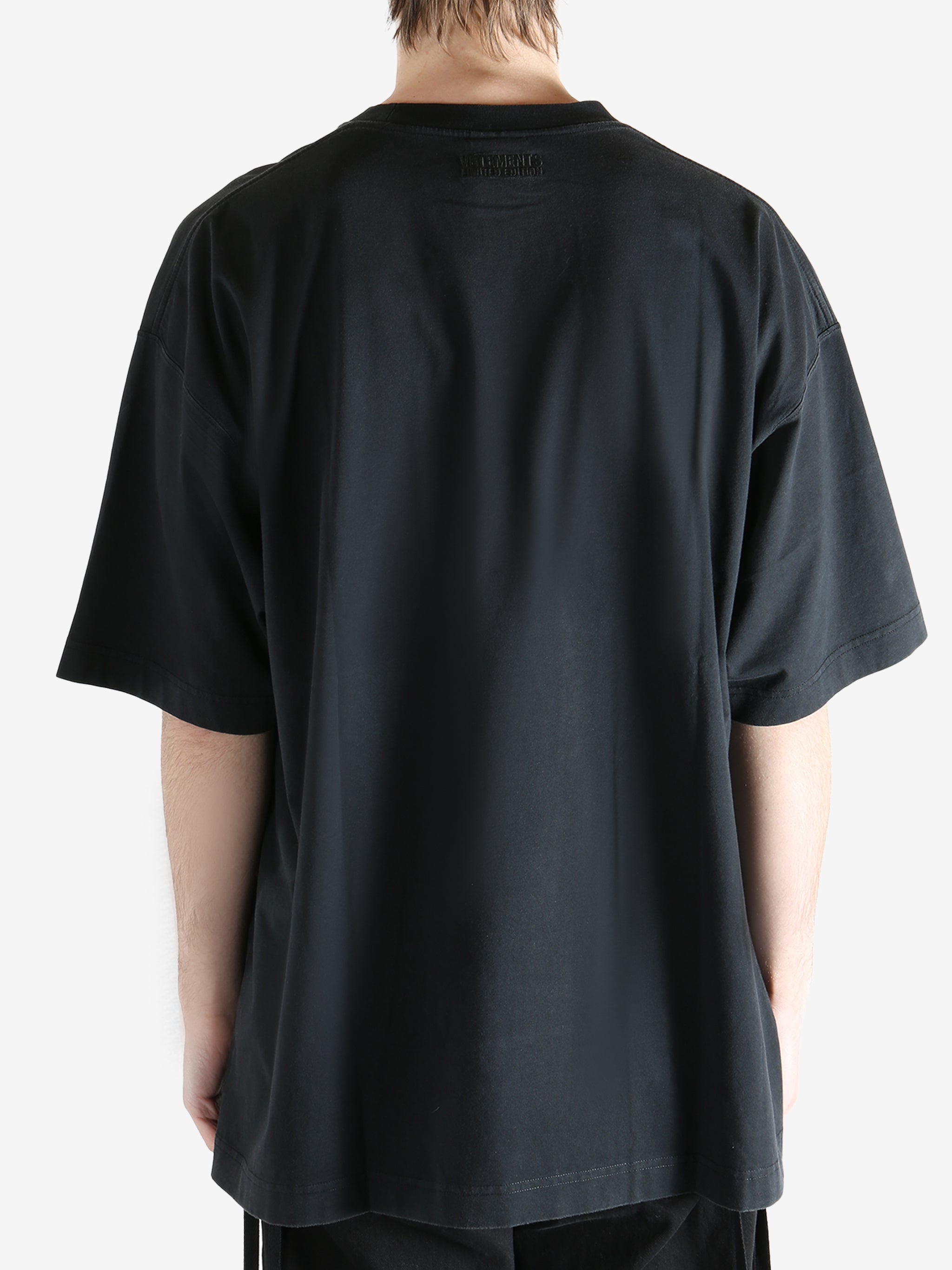 Black t-shirt worn by a person, showing the t-shirt's fit