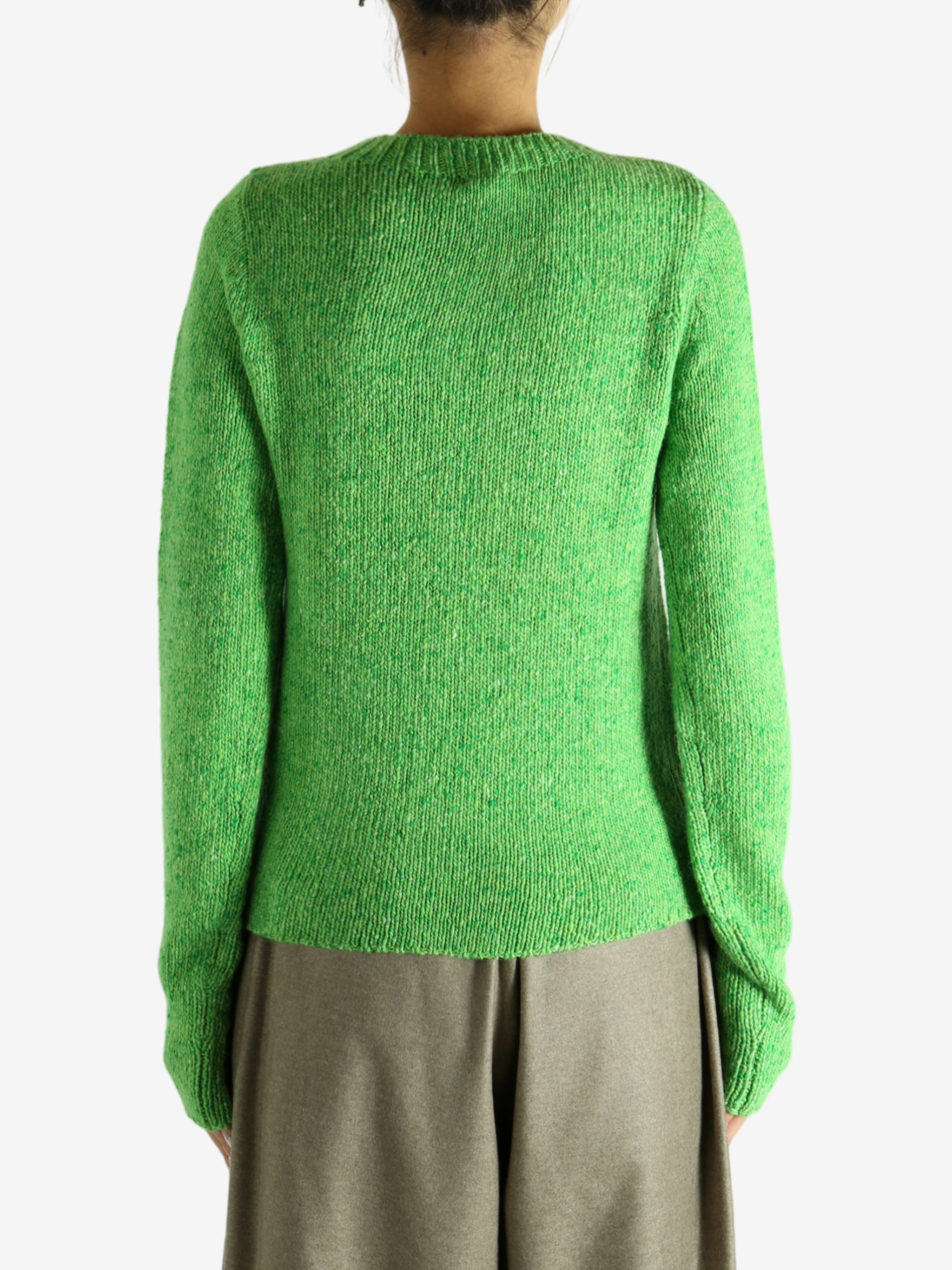 Green knitwear worn by a person, showing the knitwear fit